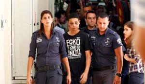Tariq Khdeir, an American of Palestinian descent, is escorted by Israeli prison guards during an appearance at Jerusalem magistrate's court
