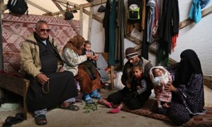 Jibril, left, lost two of his four grandchildren to hypothermia in the storms last month. The family now live in a tiny plastic-covered wooden structure in Beit Hanoun with a blanket for a door. Photograph: Belal Hasna